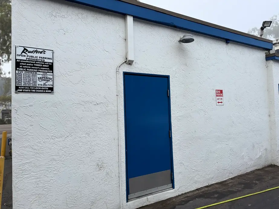 Clean white stucco wall and a blue door on a restaurant frontage