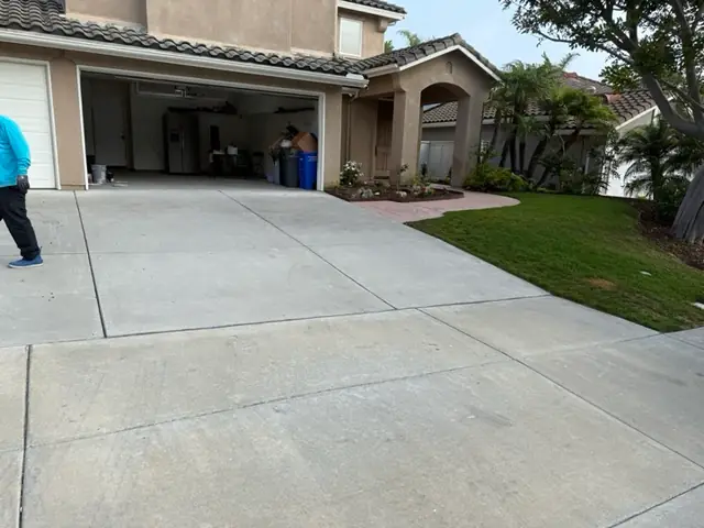 Washed concrete driveway in front of a stucco house