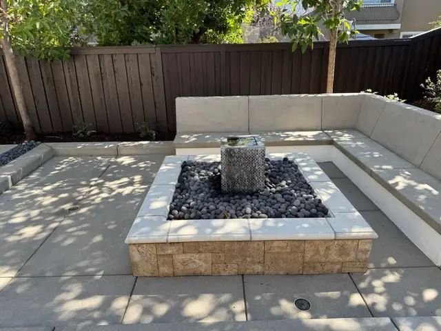 Washed paver patio around a stone fire and water feature